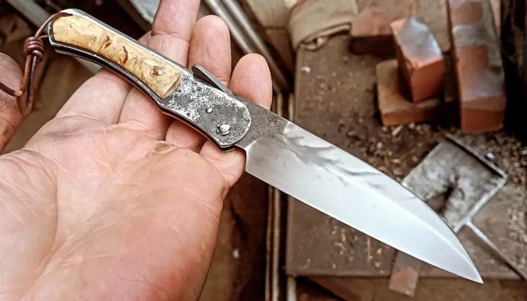 Couteau artisanal avec une lame en acier carbone et un manche en bois rouge.