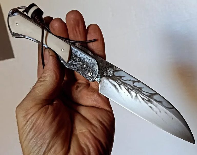 Couteau artisanal avec une lame en acier carbone et un manche en bois rouge.