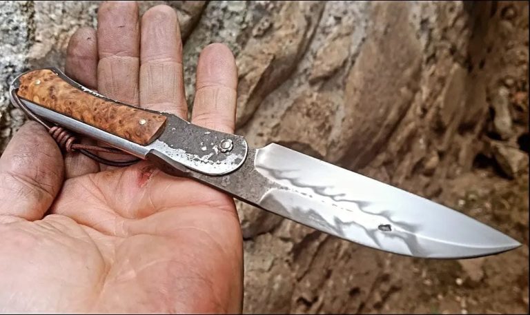 Couteau artisanal avec une lame en acier carbone et un manche en bois rouge.