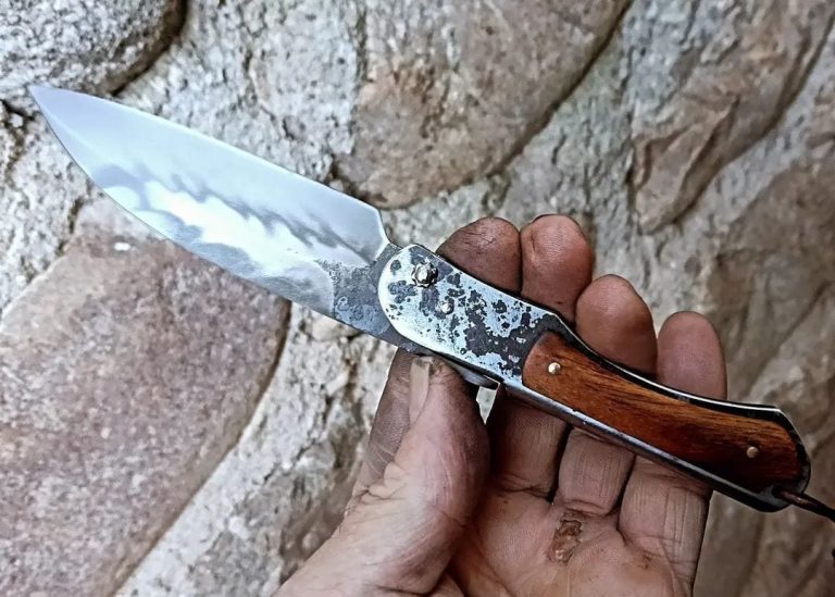 Couteau artisanal avec une lame en acier carbone et un manche en bois rouge.