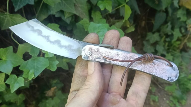 Couteau artisanal avec une lame en acier carbone et un manche en bois rouge.
